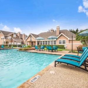 Large pool at Highlands of Valley Ranch surrounded by brightly colored patio furniture and multiple seating areas