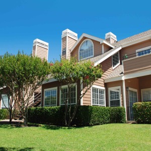 Exterior facade of Highlands with green grass, blue skies, and blooming crepe myrtles